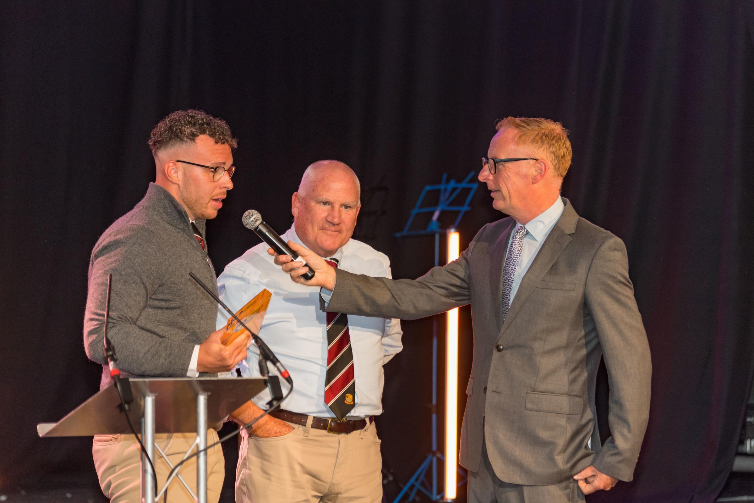 Preston Lodge RFC (captained by Jack Gordon, pictured) wins the Sporting Champion of the Year Award Host Bryan Burnett at East Lothian Community Champion Awards 2024. Also pictured is the clubs Johnston Craig. Image: Gordon Bell